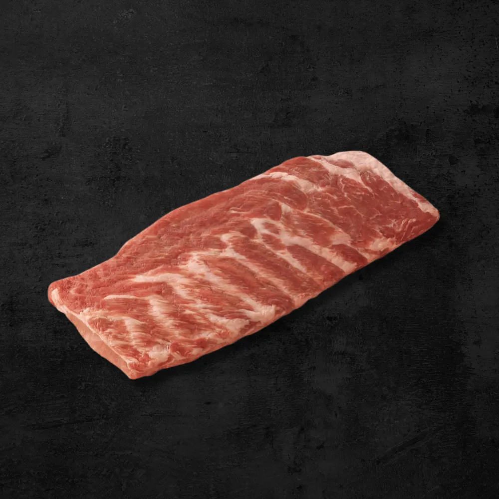 Costilla San Luis de cerdo con hueso sobre fondo oscuro