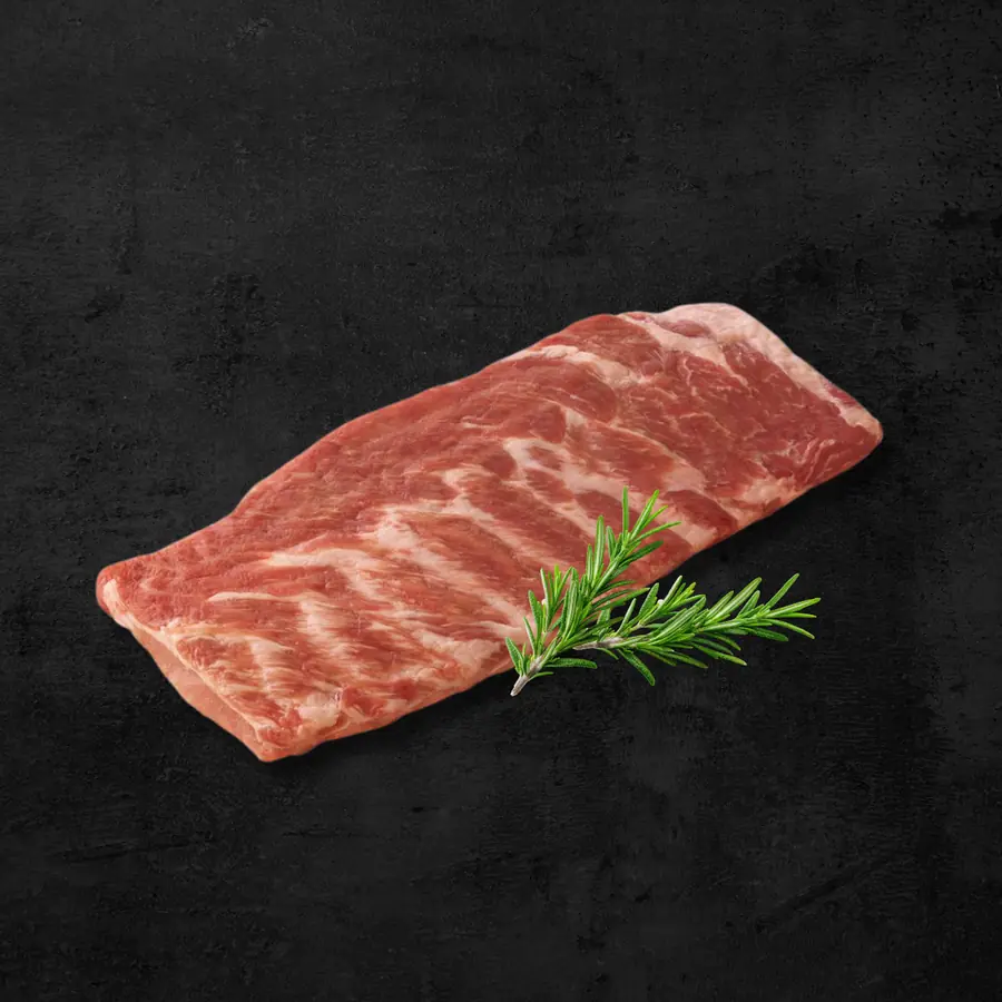 Costilla San Luis de cerdo con hueso sobre fondo oscuro